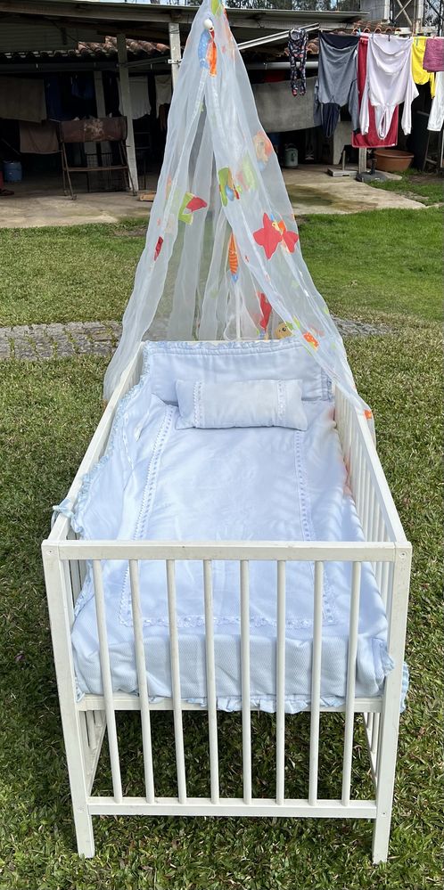 Cama de bebê com colchão e textil em bom estado