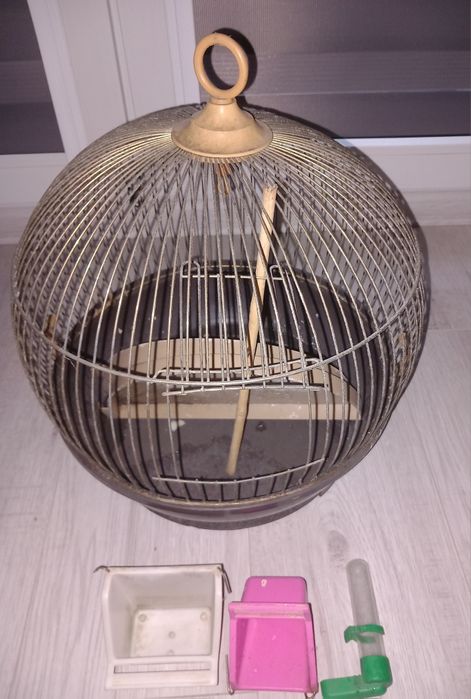 Klatka dla ptaków z wyposażeniem.