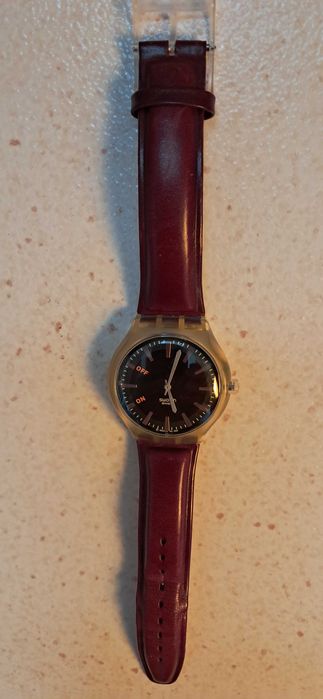 Relógio Swatch com fundo preto e bracelete pele castanha, impecável