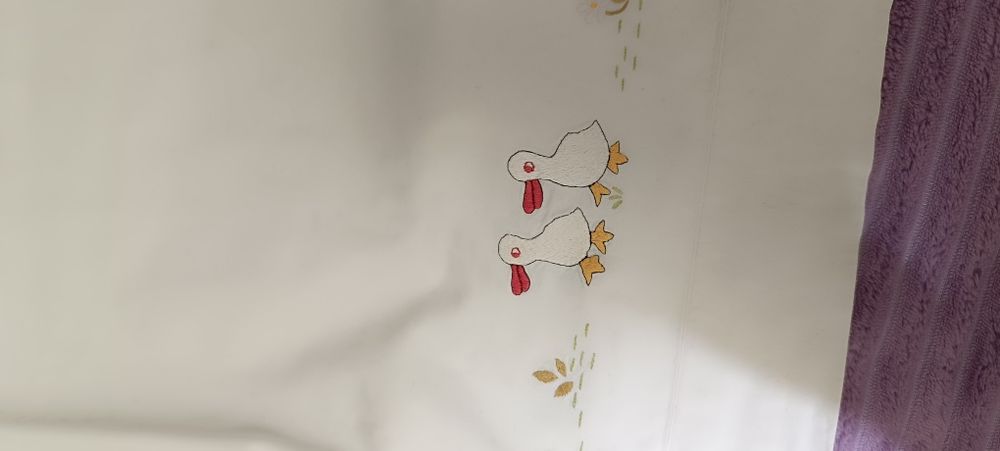 Lençol para cama de criança com patos e flores bordados