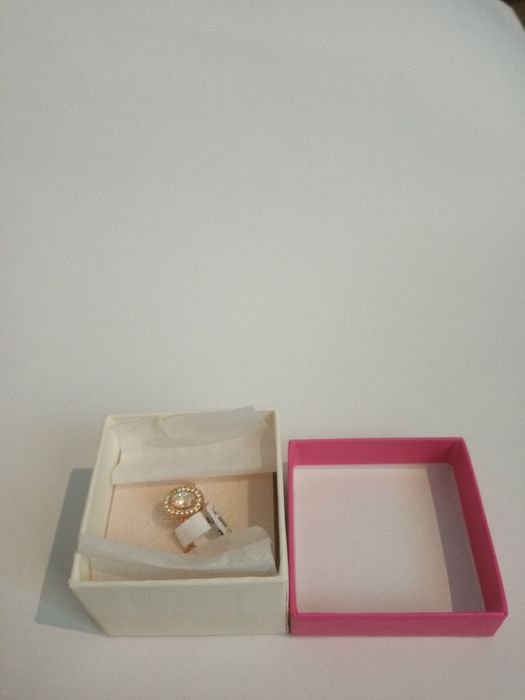 Anel dourado com pequenos cristais a rodear um cristal grande.