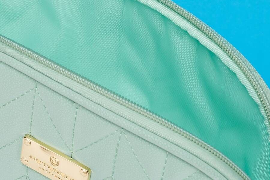 praktyczna kosmetyczka damska w kolorze zielonym pokryta jodełkowym