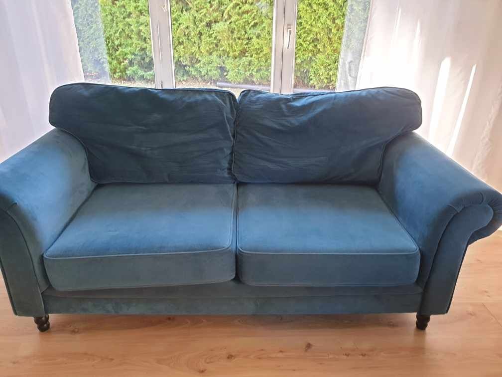 Nowoczesna sofa w szmaragdowym kolorze.