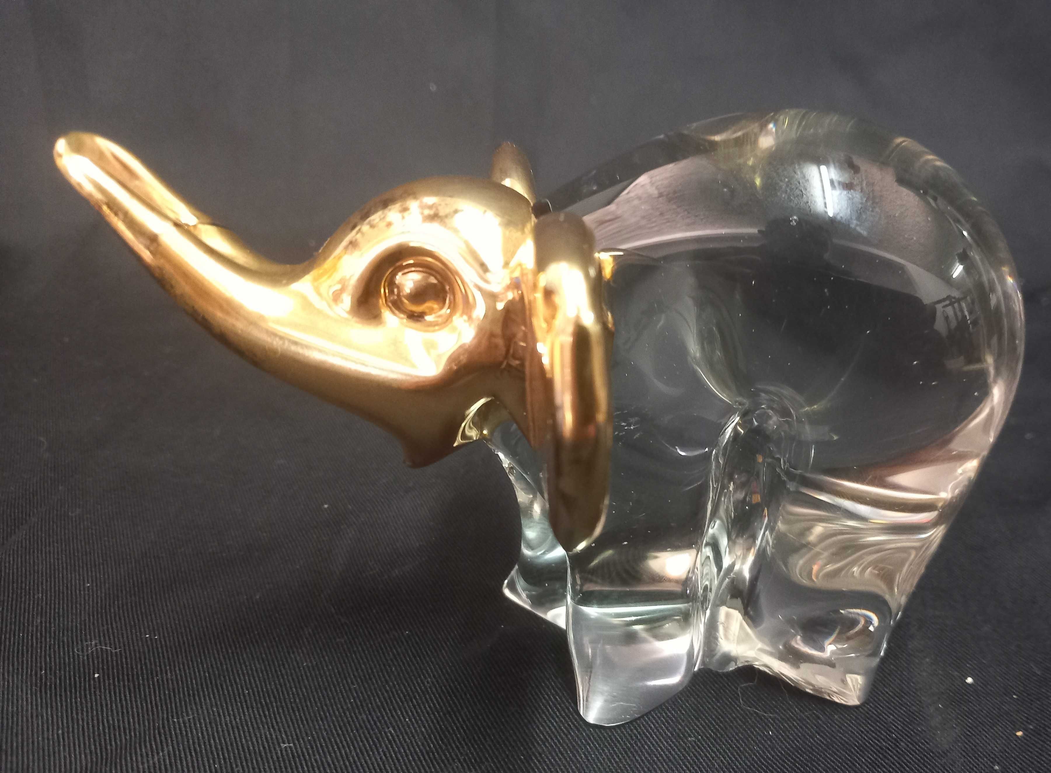 Estatueta de elefante em vidro transparente com detalhes em dourado.