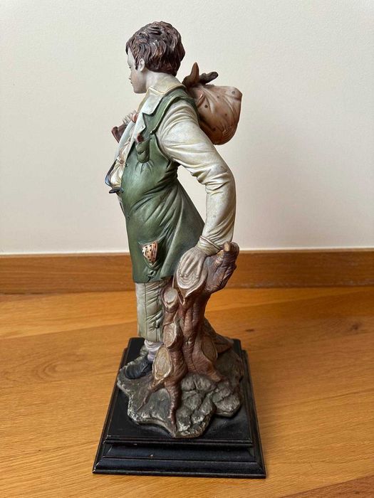Estatueta de menino com saco ao ombro