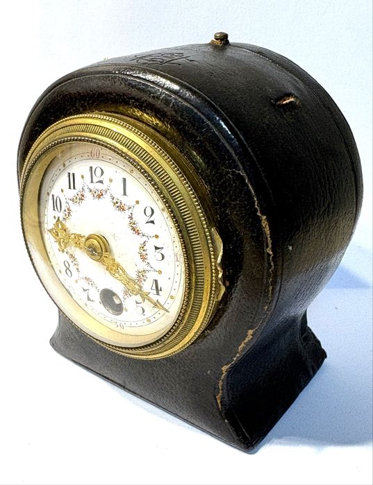 Antigo relógio de viagem com mostrador esmaltado e caixa em couro