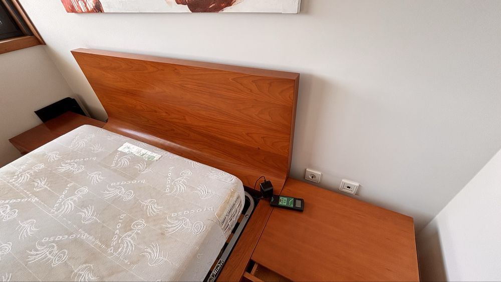 Cama casal com mesinhas de cabeceira e banco de apoio em cerejeira