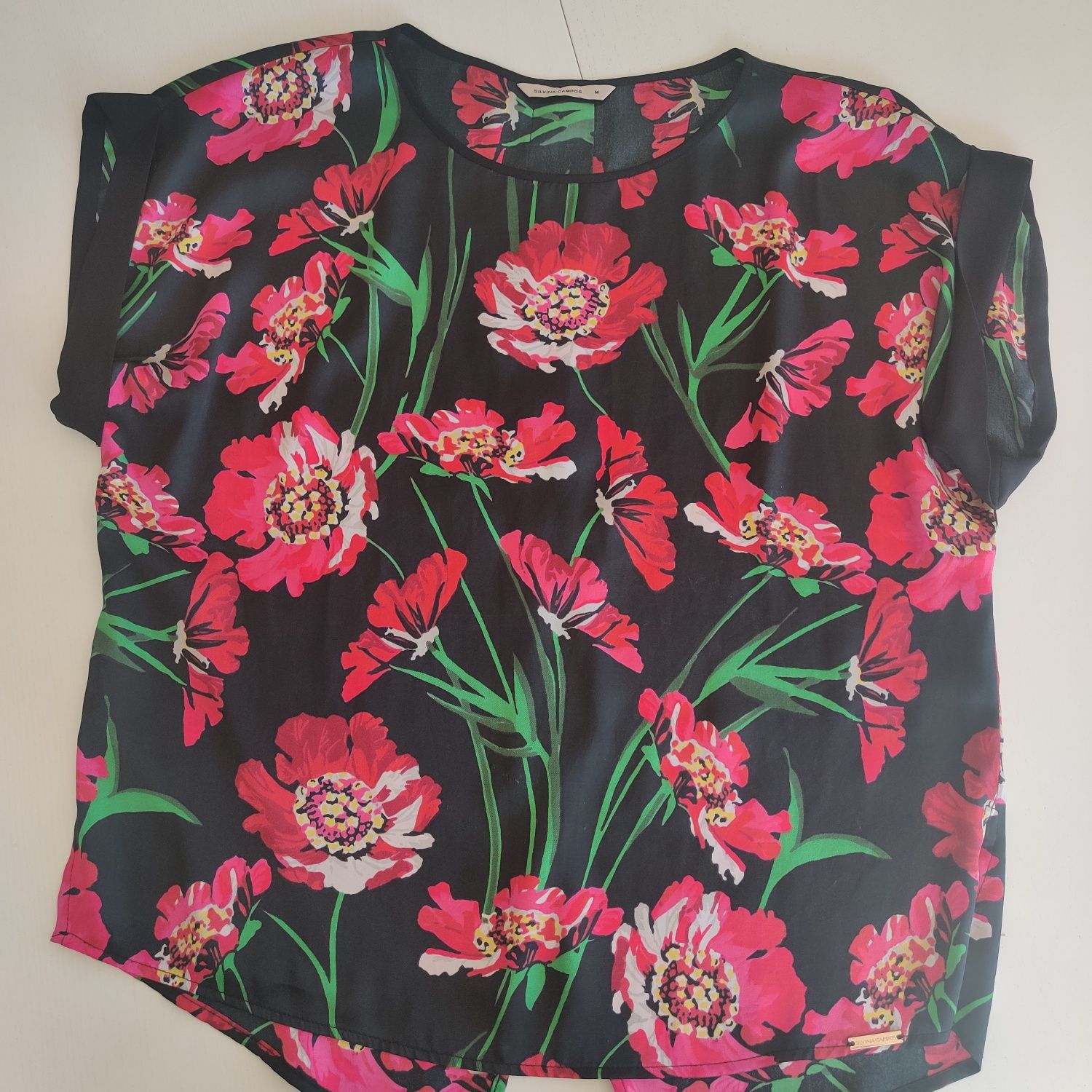 Blusa preta com flores, da marca Silvina Campos