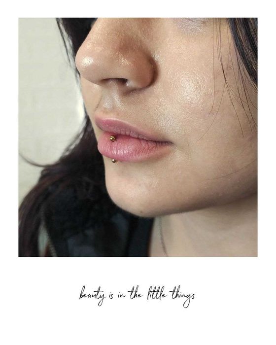 Piercings nas sobrancelhas, lábios e nariz.