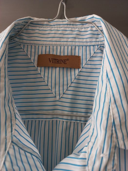 Camiseiro branco com riscas azuis.