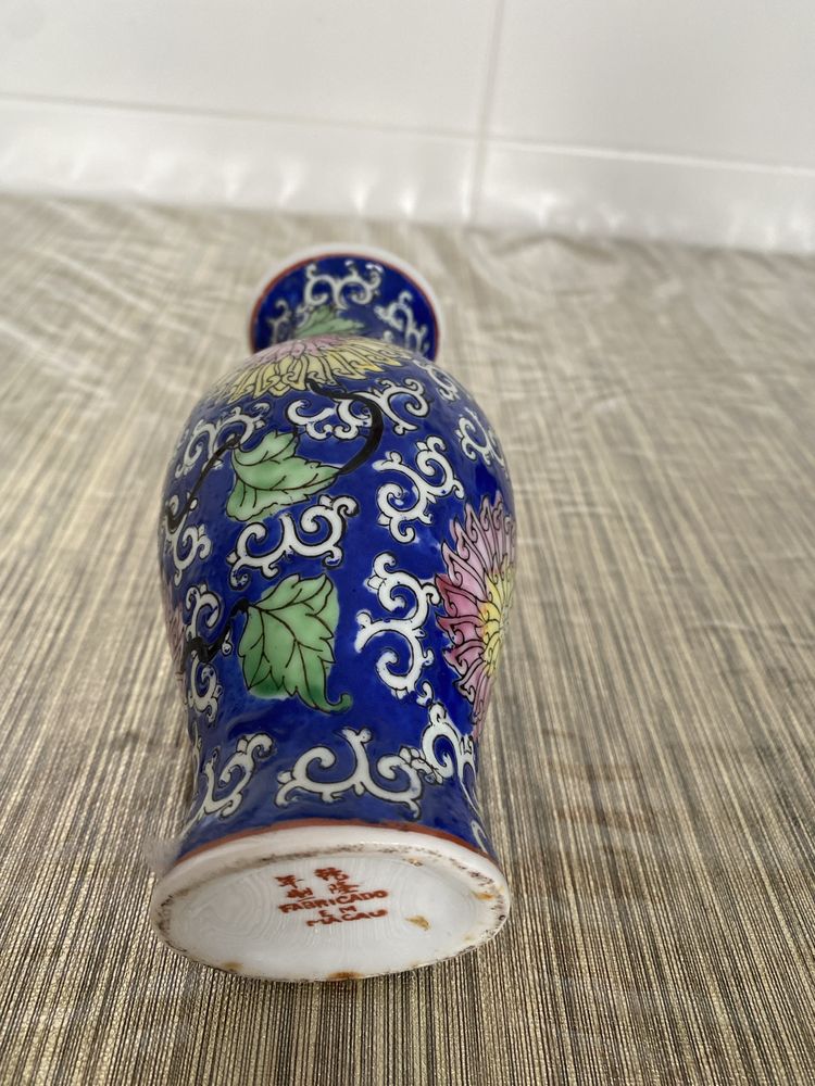 Vaso antigo pequeno com flores entrelaçadas