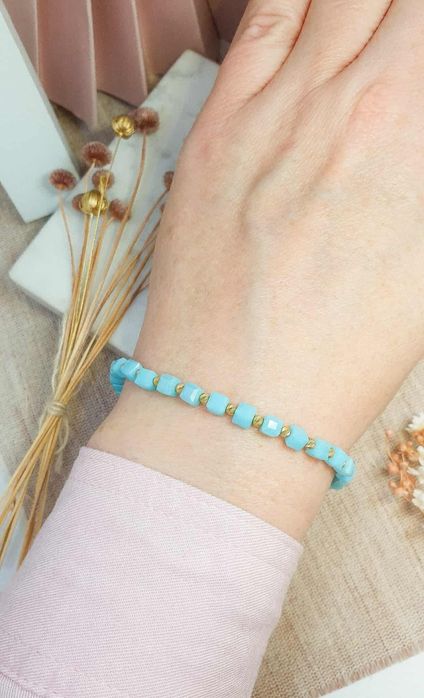 Bransoletka na sznureczku z niebieskimi koralikami.i I złotymi kulkami