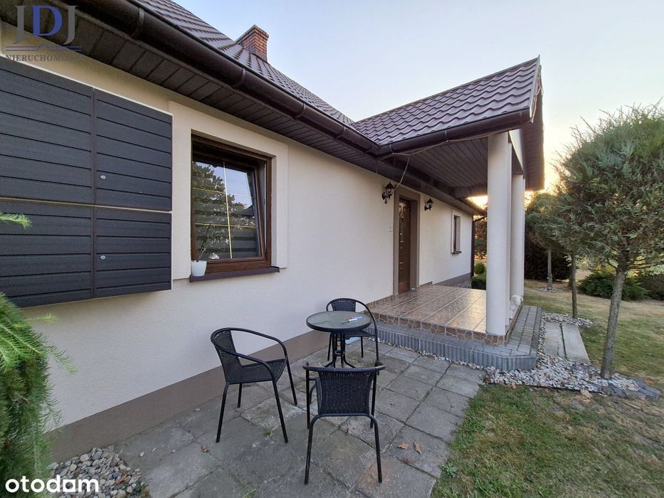 Urokliwy drewniany dom z duszą wśród zieleni.