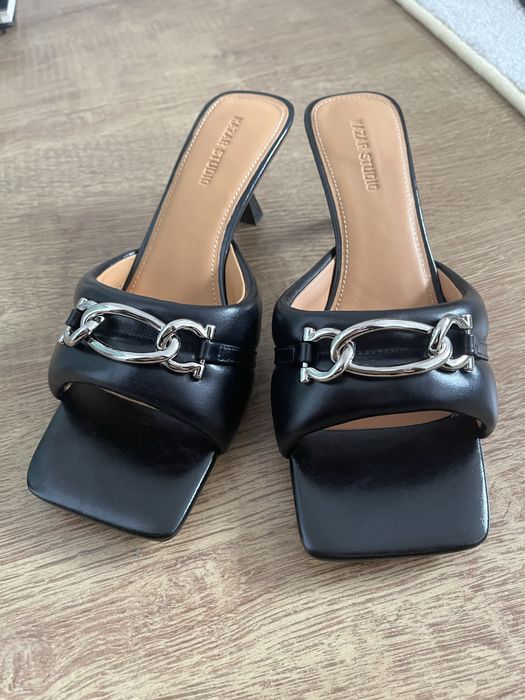 Skórzane klapki na obcasie ozdobione łańcuszkiem