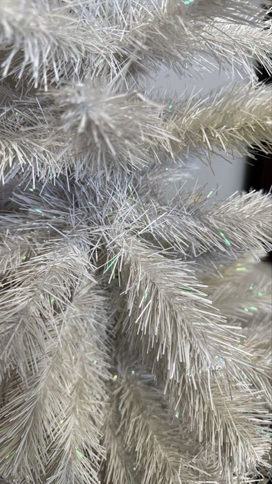 Biała sztuczna choinka z bombkami i lampkami