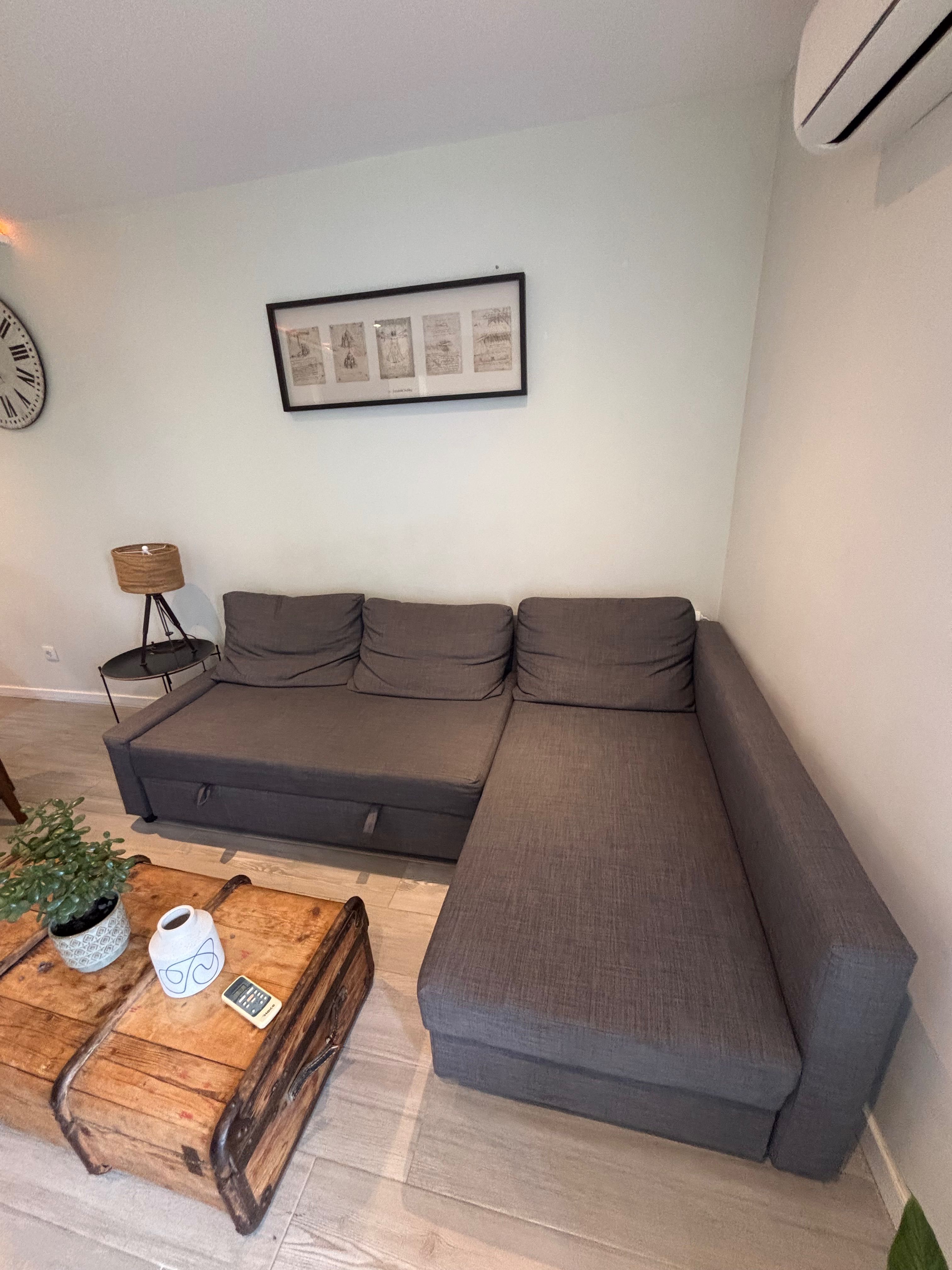 Sofá cama preto IKEA com chaise long e espaço de arrumação