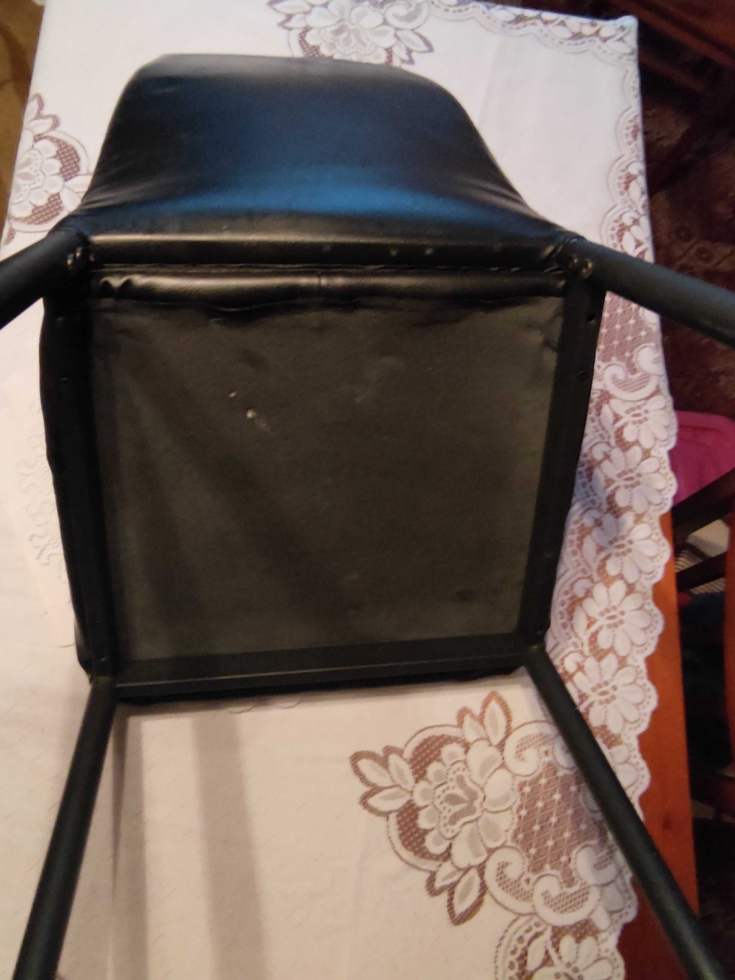 Krzesło czarne o konstrukcji metalowej.