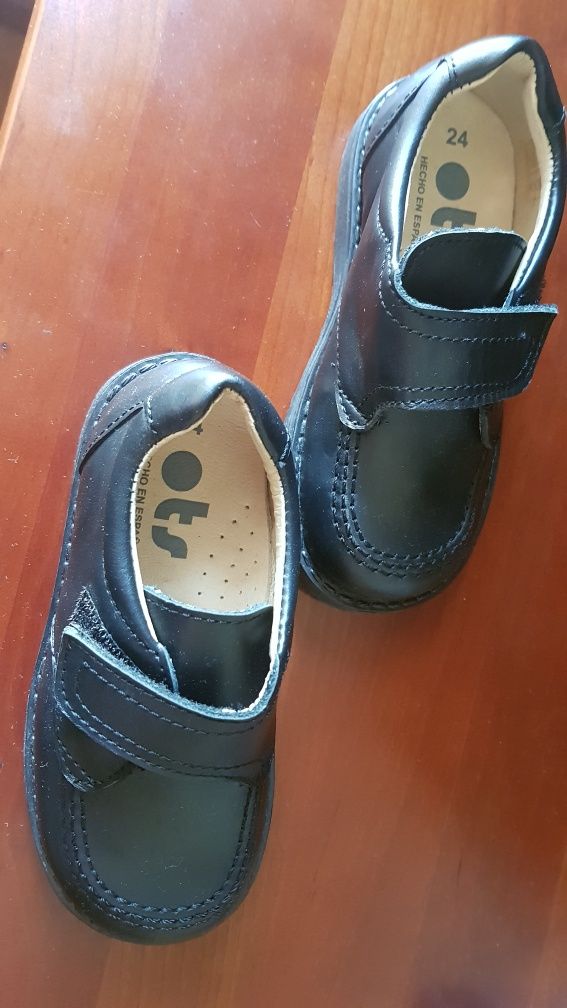 Sapatos novos de criança em pele