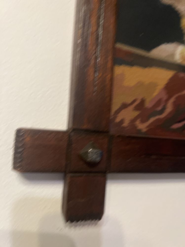 Stary wyszywany ręcznie obraz w drewnianej ramie za szkłem