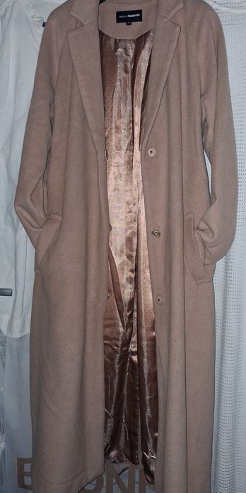 beżowy płaszcz z paskiem marki KappAhl.