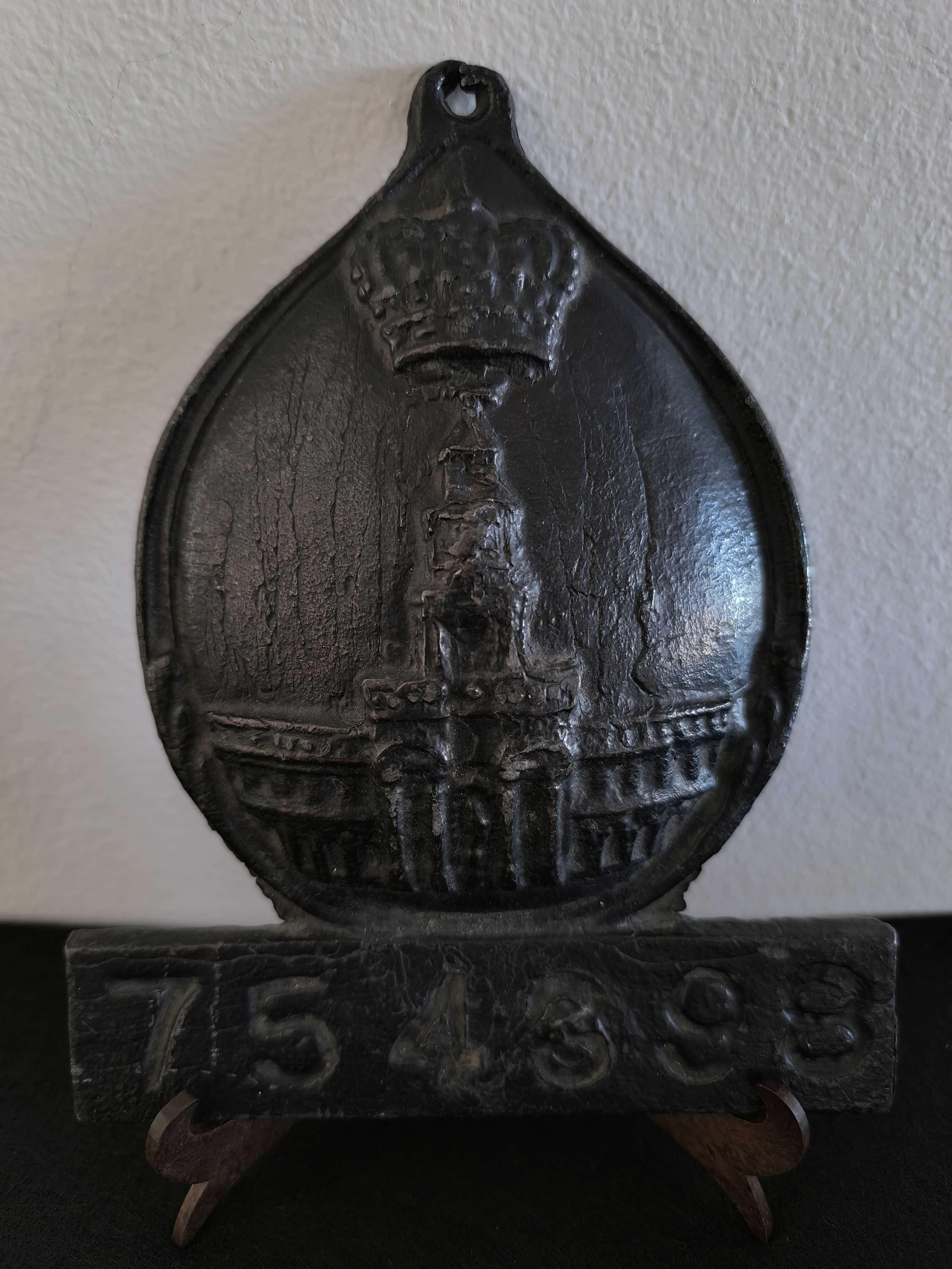Placa de metal com o n.º 754398, marcada com o emblema da seguradora