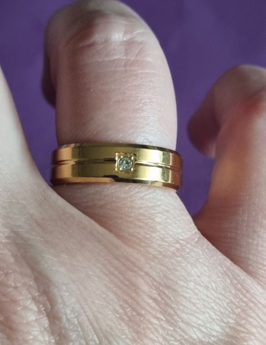 Anel/aliança dourado, em aço inoxidável, com 1 brilhante. T17