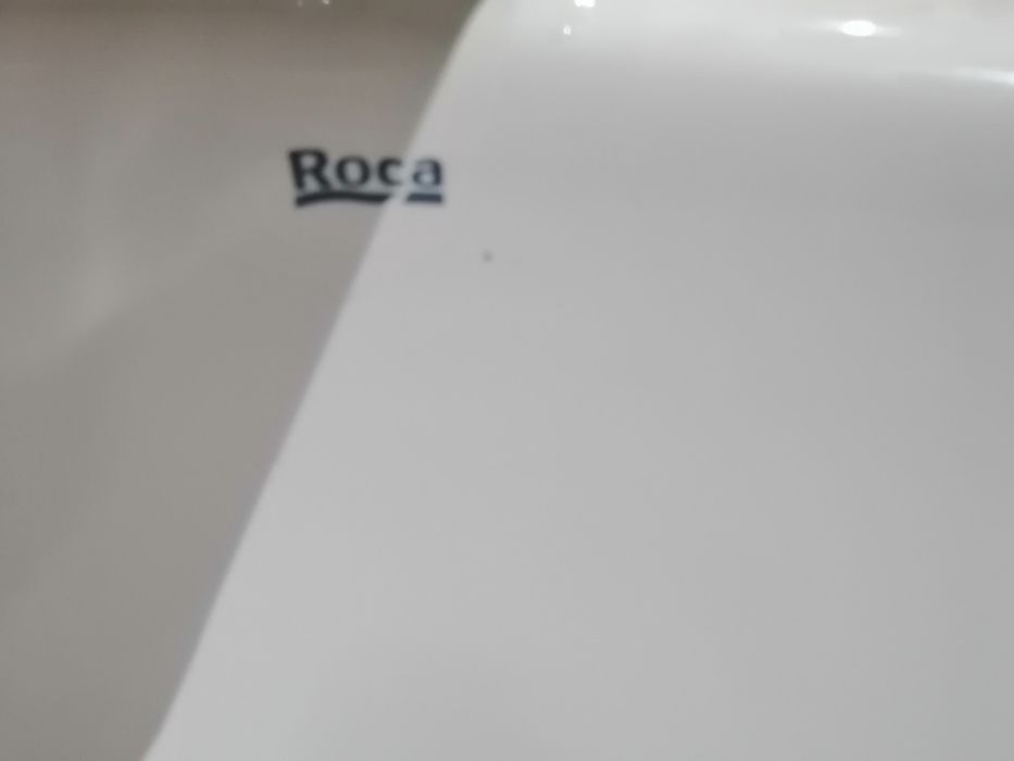 Lavatório branco com pedra de cor beje torneira misturadora.