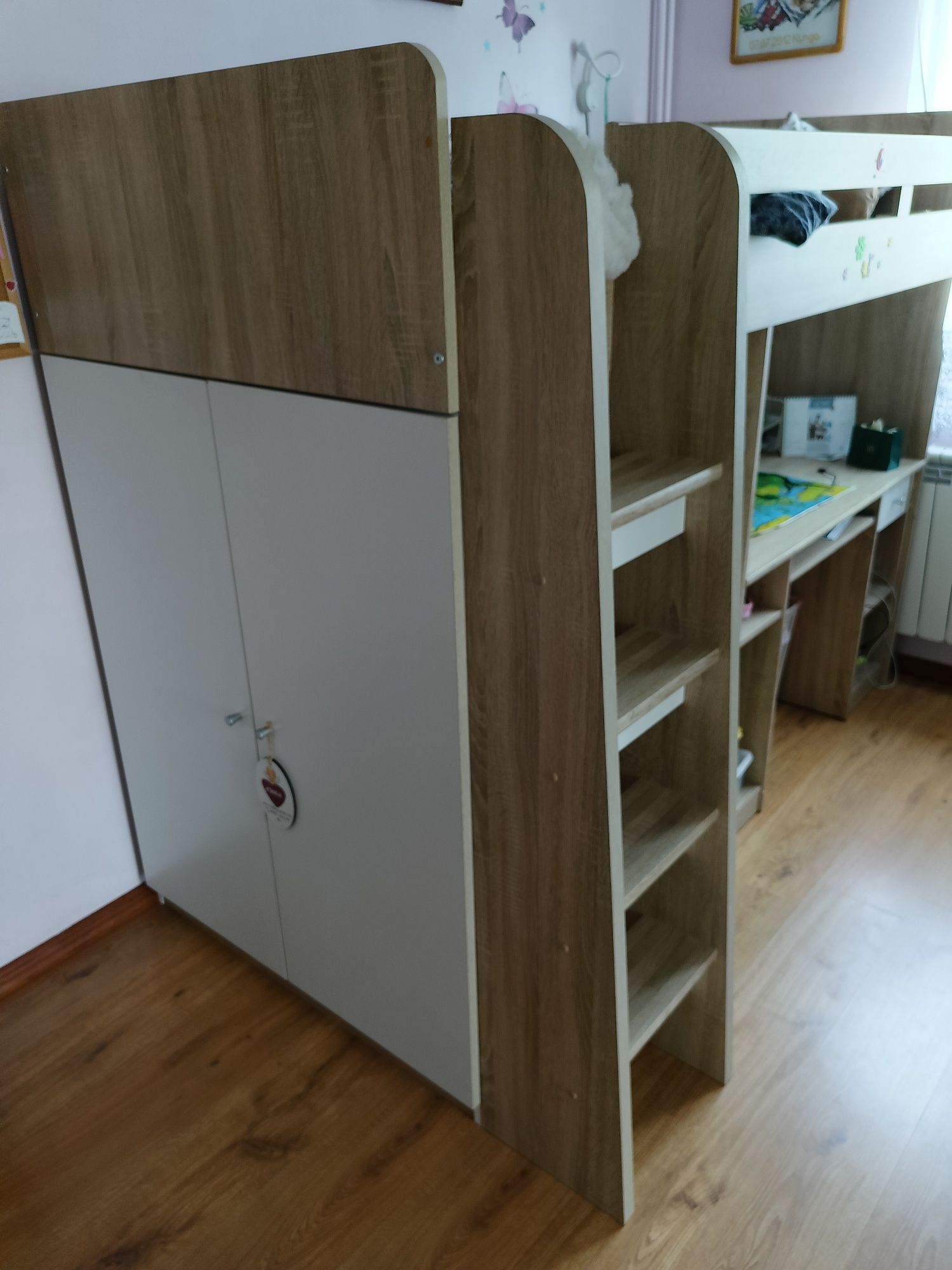 Łóżko piętrowe z szafą i biurkiem.