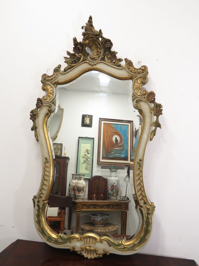 Espelho em madeira com detalhes dourados.