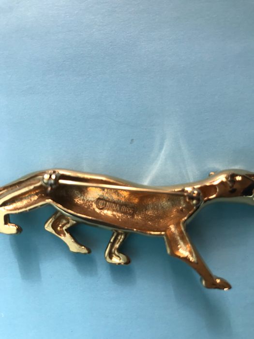 Pregadeira dourada da marca Nina Ricci