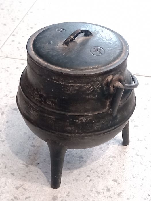Panela de ferro forjado antiga para aquecer sobre a lenha