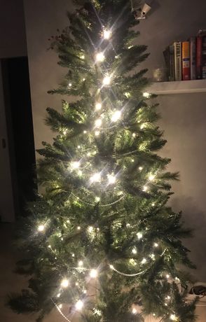 Árvore de Natal com enfeites variados e três conjuntos de luzes