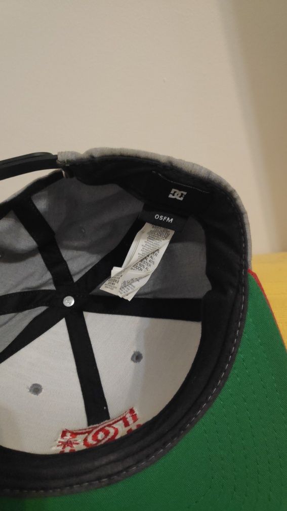 Boné DC cinzenta com detalhes vermelhos e verdes