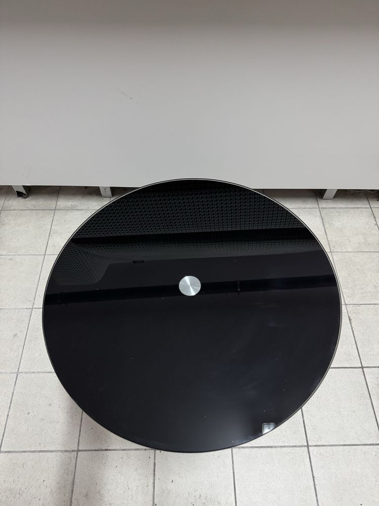 Mesa de apoio com tampo de vidro preto.