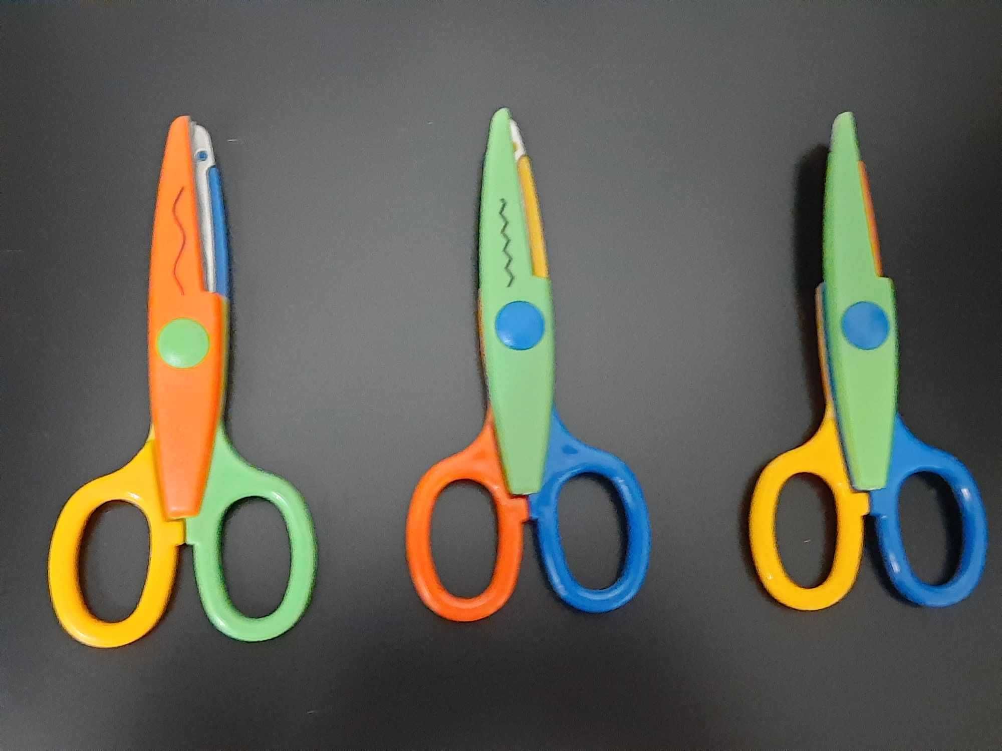 Trzy różnokolorowe nożyczki wycinające różne wzory