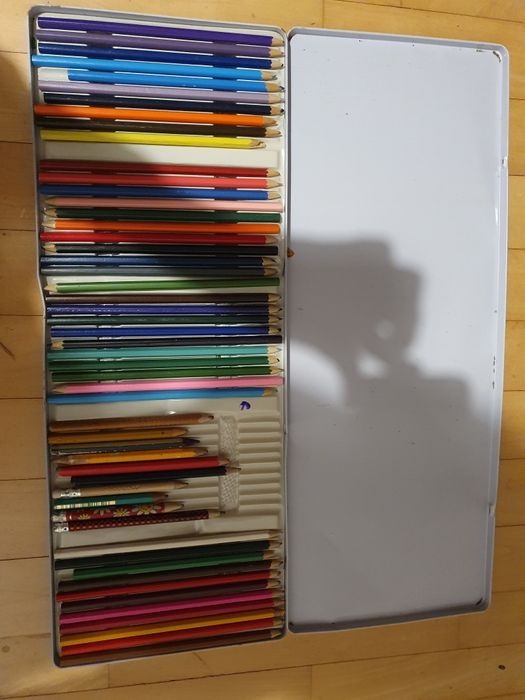 Zestaw używanych kredek w metalowym pudełku