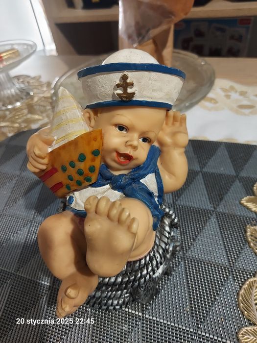 Figurka dekoracyjna chłopiec w marynarskiej czapce z łódką na plaży