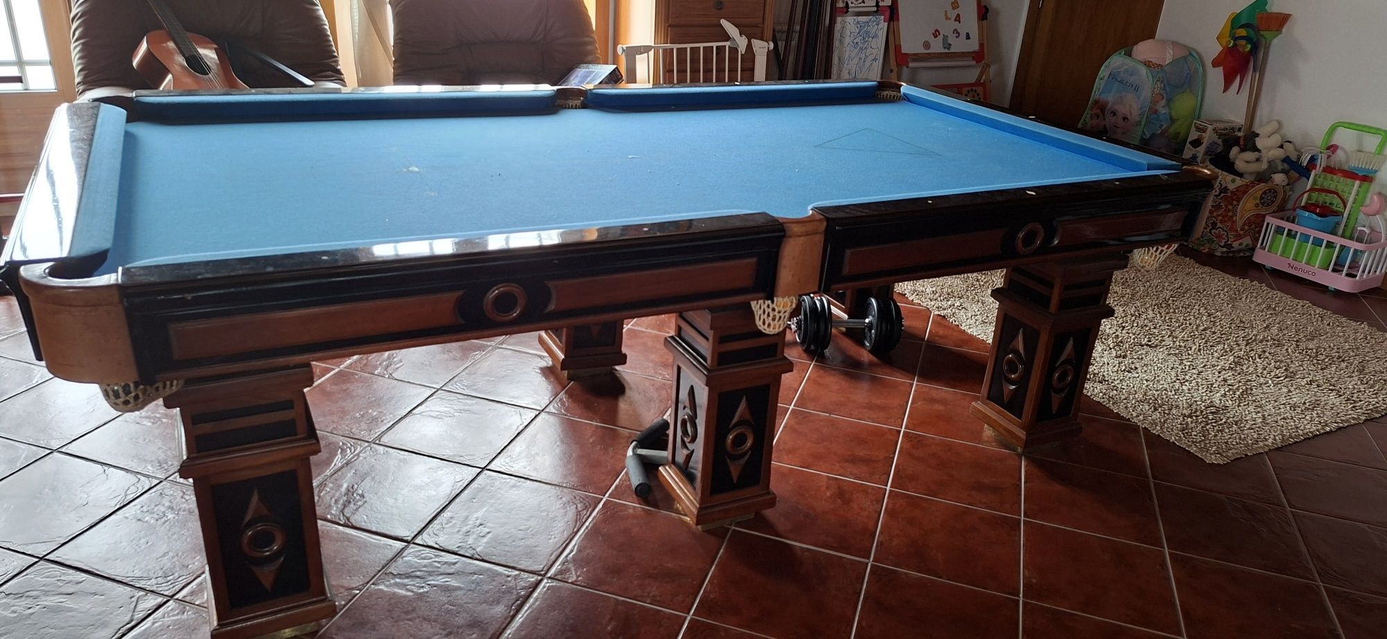 Mesa de bilhar com tacos e bolas