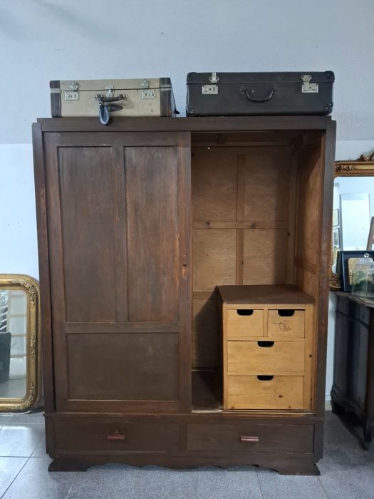 Roupeiro em madeira maciça com portas de correr.