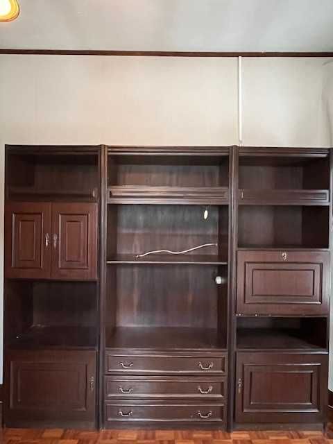 Armário em madeira escura, de grandes dimensões.