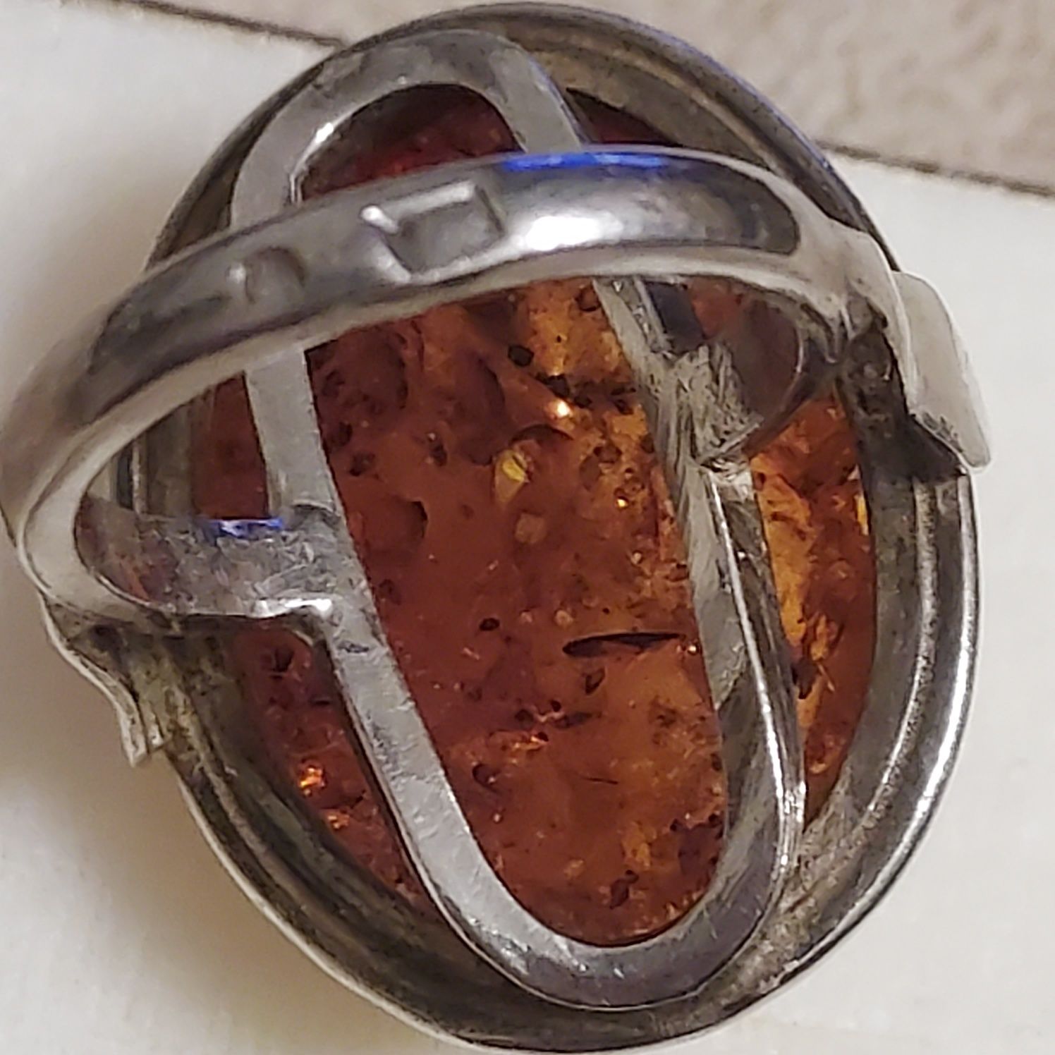 Duzy srebrny pierścionek ze złocistym bursztynem.