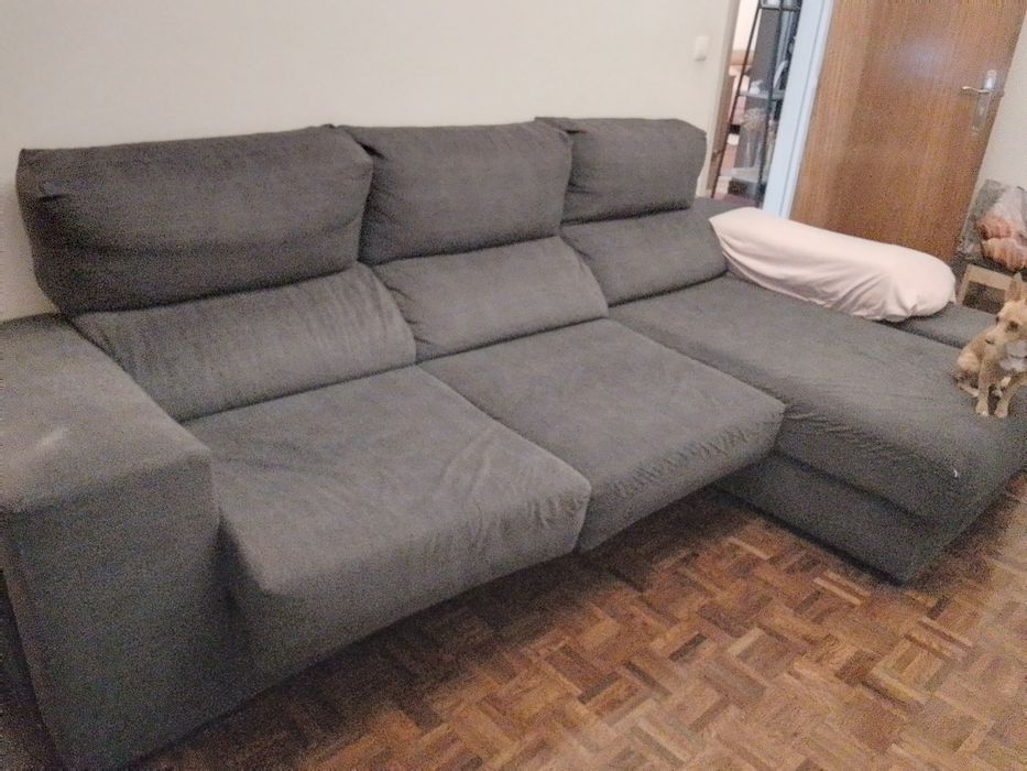 Sofá com chaise long e assentos deslizantes.