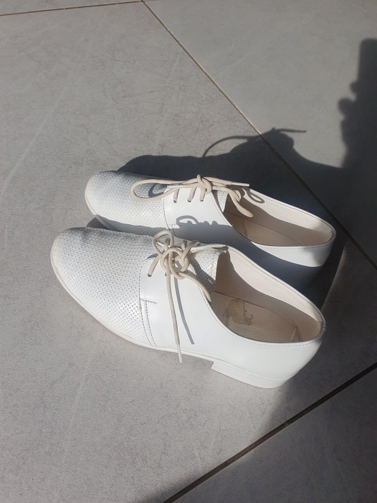 Białe, chłopięce buty komunijne.