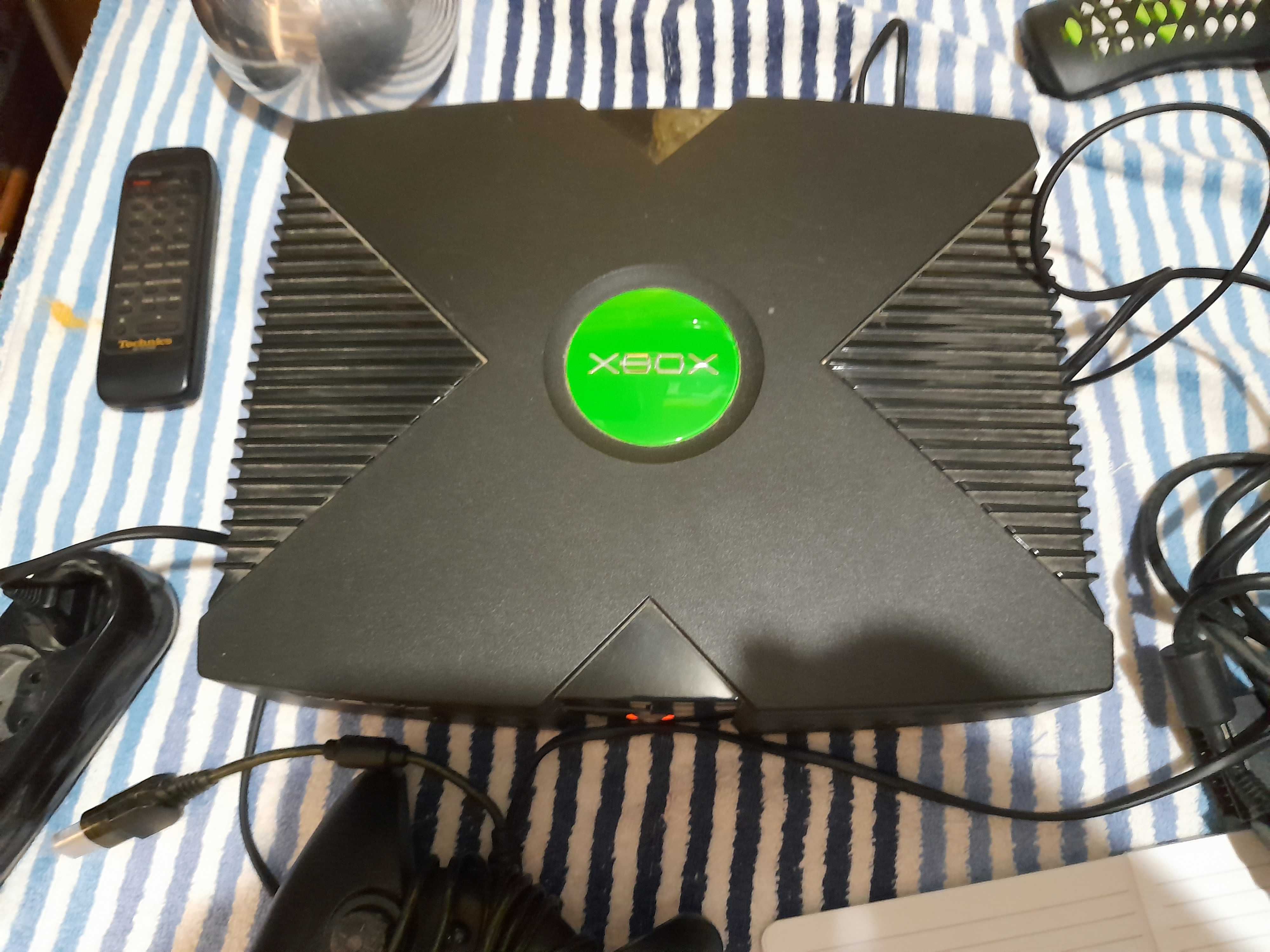 Consola de jogos X-BOX antiga desbloqueada usada com cabos e comando.