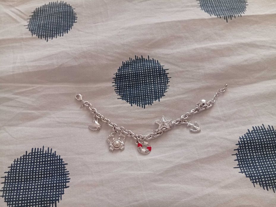 Pulseira nova, em metal prateado, com pendurezas de motivos náuticos