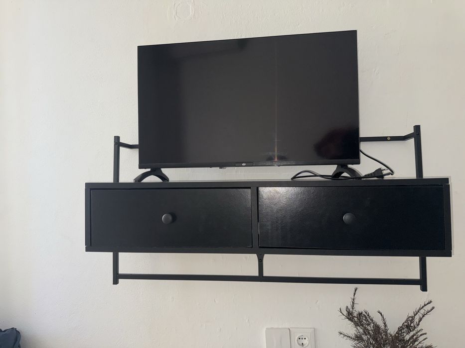 Estante preta pendurada para tv