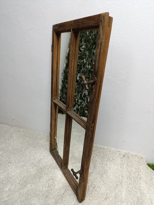 Lustro w starej drewnianej ramie okiennej.