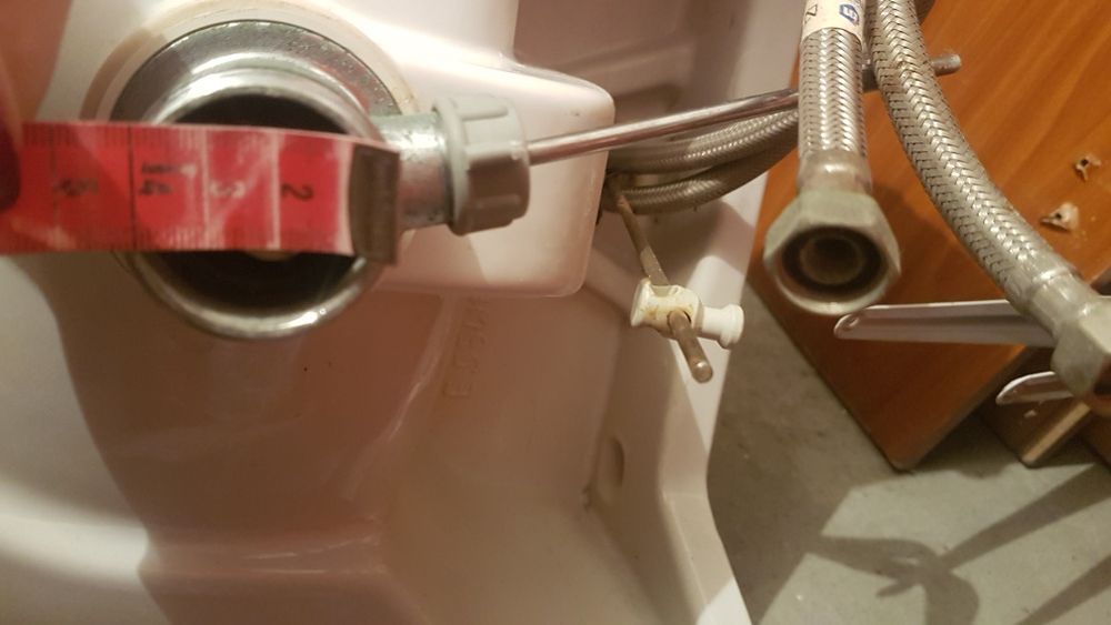 Umywalka biała z baterią i rurkami