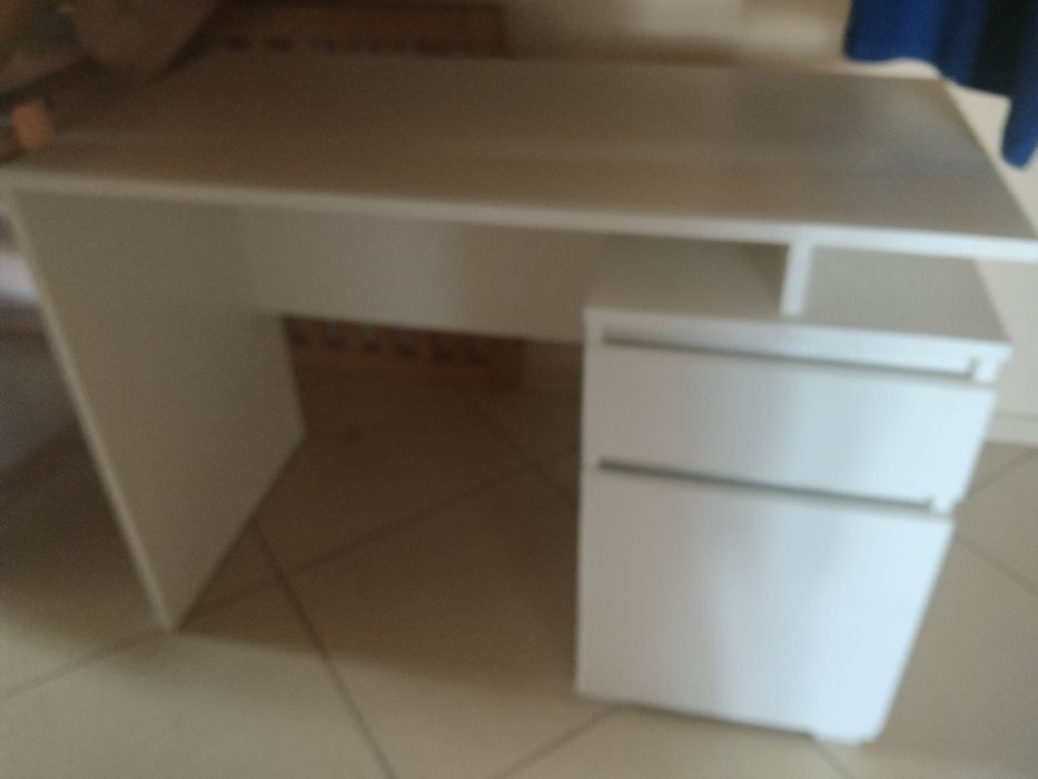 Duże, białe biurko z szufladami.