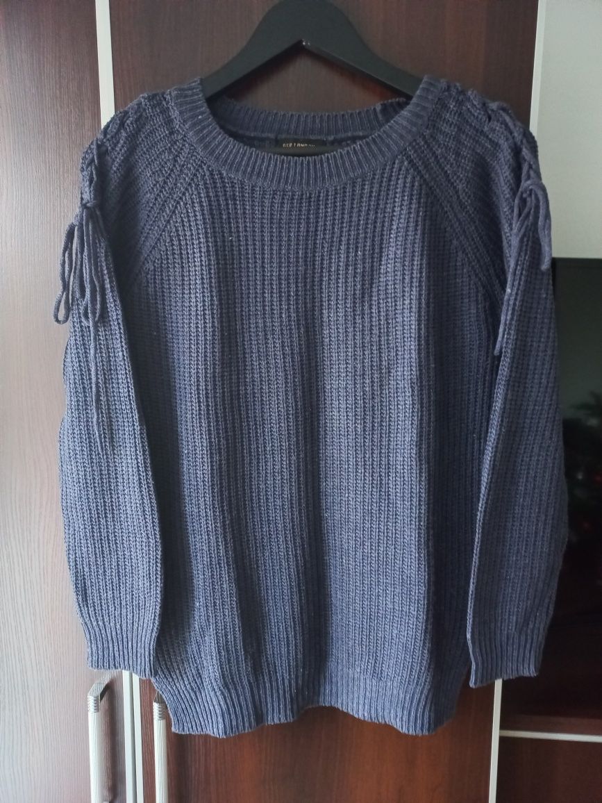 Granatowy sweter z kokardkami na ramionach